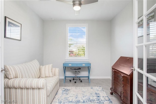 office area with light tile patterned floors, baseboards, and a ceiling fan