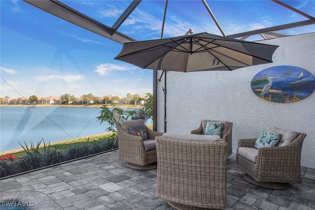 view of patio with a lanai, a water view, and an outdoor living space