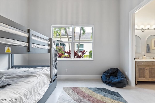 bedroom featuring ensuite bath, sink, and light tile patterned floors