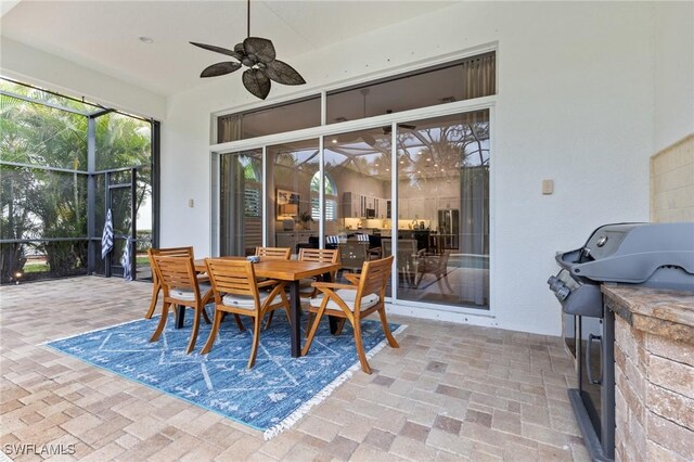 exterior space featuring glass enclosure, ceiling fan, and area for grilling