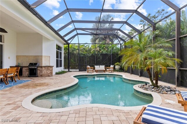 view of swimming pool featuring grilling area, an outdoor hangout area, a patio, and an outdoor kitchen