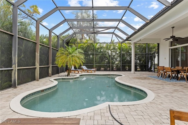 view of swimming pool featuring ceiling fan, a patio area, and glass enclosure