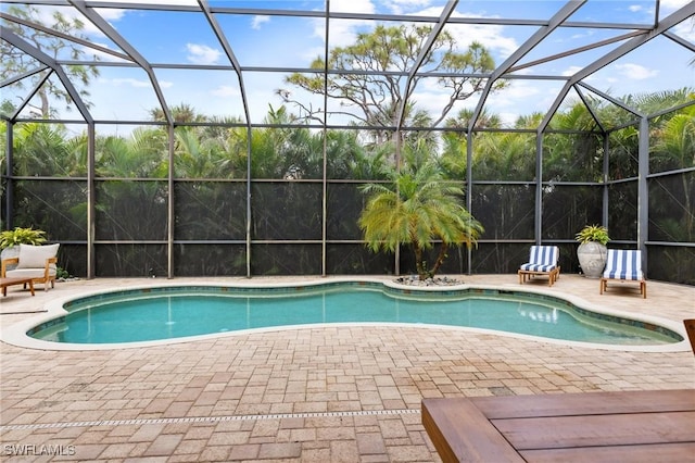 view of pool featuring glass enclosure and a patio area