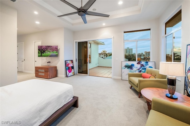 carpeted bedroom with ceiling fan and a tray ceiling