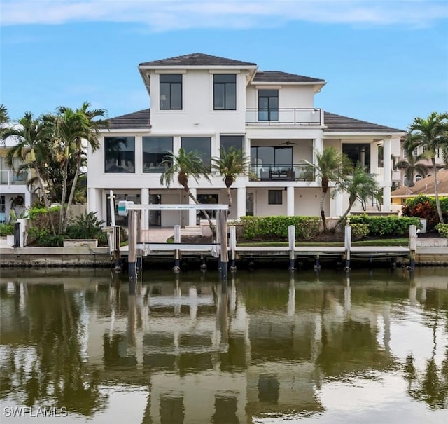 rear view of property with a balcony and a water view