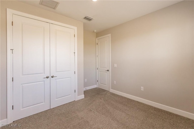 unfurnished bedroom featuring carpet floors and a closet