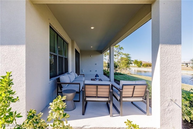 view of patio with a water view and an outdoor living space