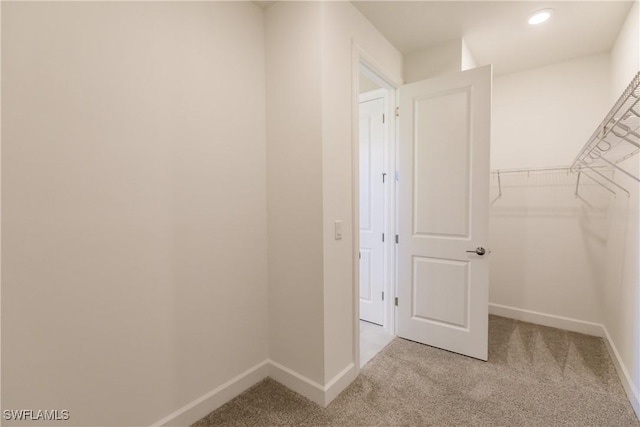 walk in closet with light colored carpet