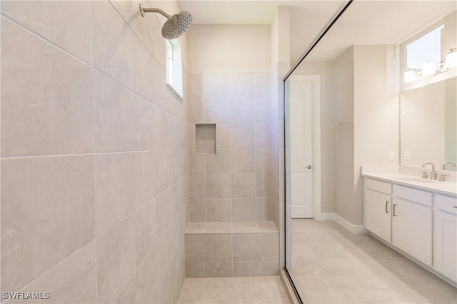 bathroom with vanity, plenty of natural light, and tiled shower