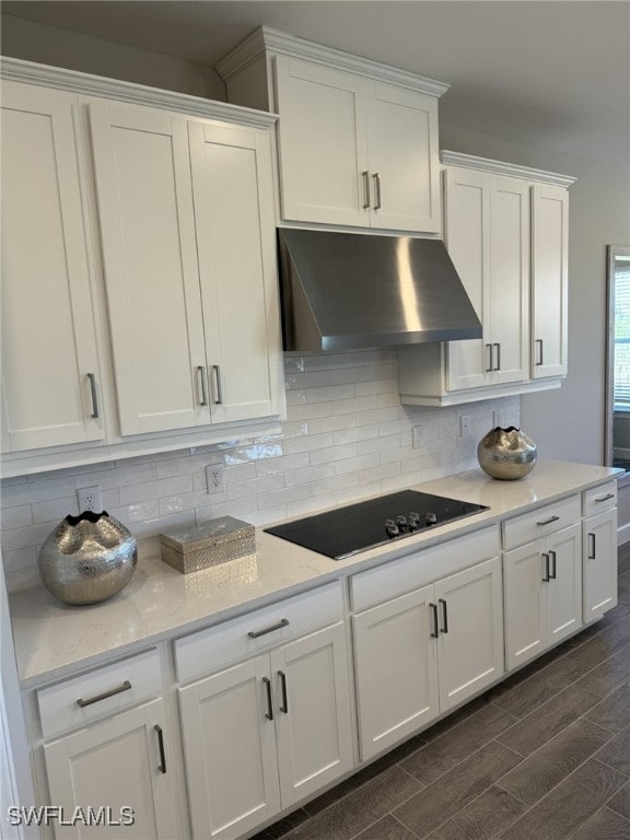 kitchen featuring black electric stovetop, white cabinetry, and light stone counters