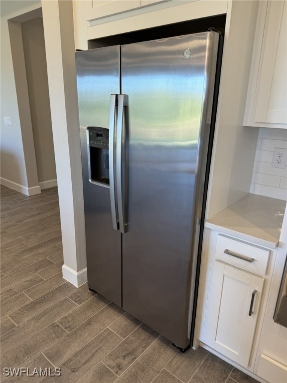 kitchen featuring dark hardwood / wood-style flooring, white cabinets, backsplash, and stainless steel refrigerator with ice dispenser