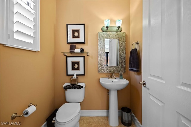 bathroom featuring toilet, tile patterned floors, and sink