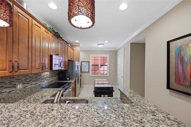 kitchen with appliances with stainless steel finishes, light stone counters, and sink