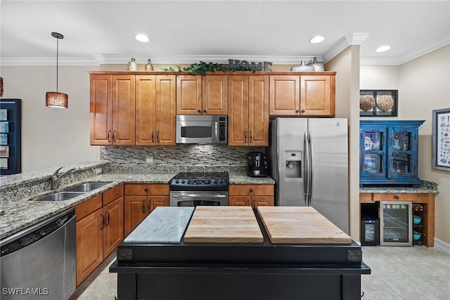 kitchen featuring sink, crown molding, hanging light fixtures, light stone countertops, and stainless steel appliances