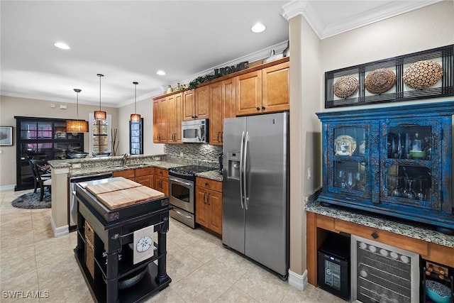 kitchen featuring kitchen peninsula, stainless steel appliances, hanging light fixtures, ornamental molding, and sink