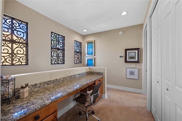 carpeted home office featuring built in desk