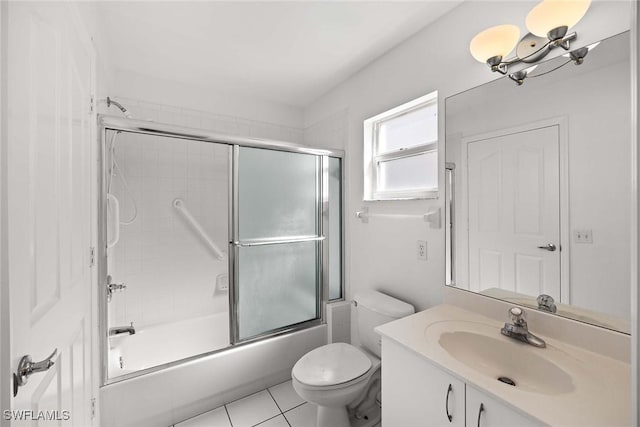 full bathroom featuring toilet, an inviting chandelier, bath / shower combo with glass door, tile patterned floors, and vanity