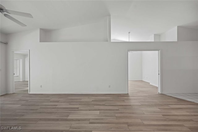 empty room with ceiling fan and high vaulted ceiling