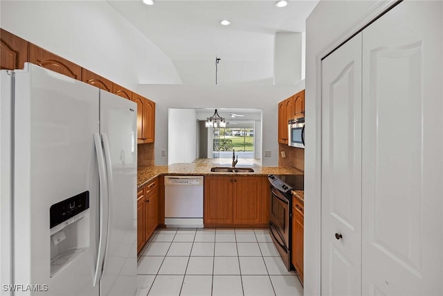 kitchen featuring appliances with stainless steel finishes, sink, backsplash, kitchen peninsula, and light tile patterned floors