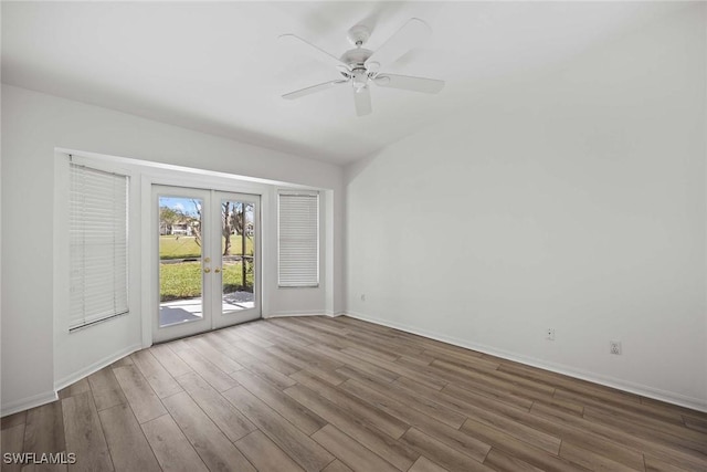 empty room featuring ceiling fan, wood-type flooring, and french doors