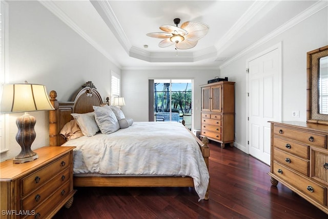 bedroom with access to exterior, a tray ceiling, ceiling fan, crown molding, and dark wood-type flooring