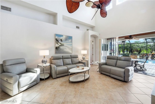 living room with light tile patterned flooring and a towering ceiling