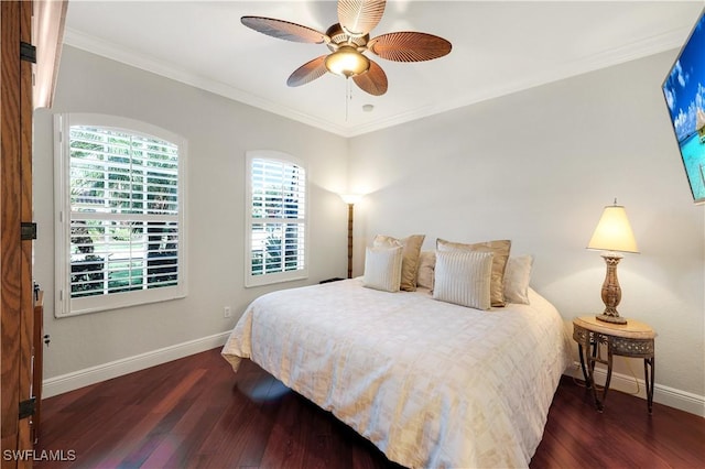 bedroom featuring dark hardwood / wood-style flooring, ceiling fan, and crown molding