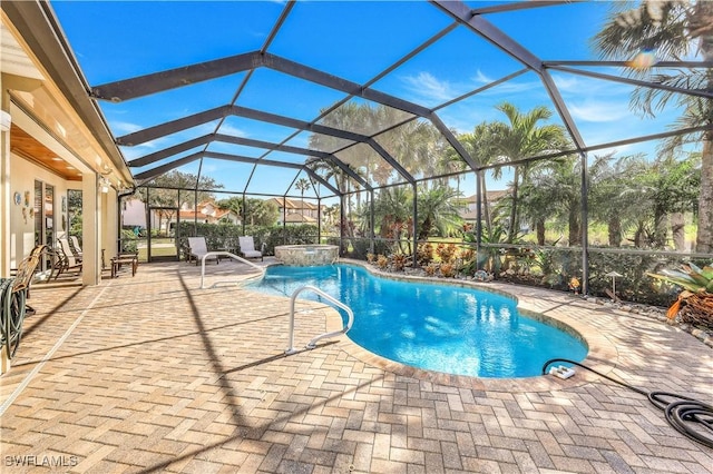 view of swimming pool featuring pool water feature, glass enclosure, a patio area, and a hot tub