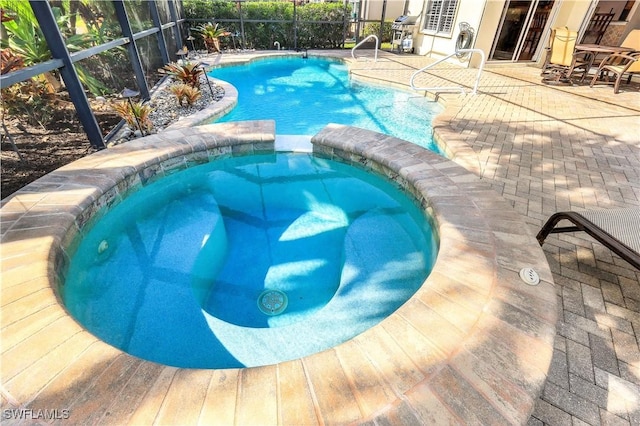 view of swimming pool featuring a patio area and an in ground hot tub