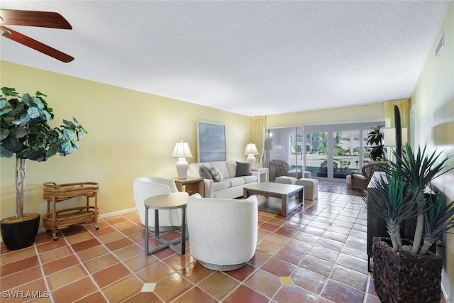 living room with a textured ceiling, tile patterned floors, and ceiling fan