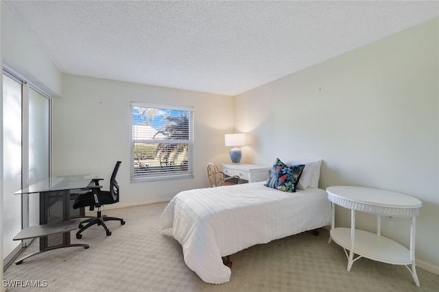 bedroom with light carpet and a textured ceiling