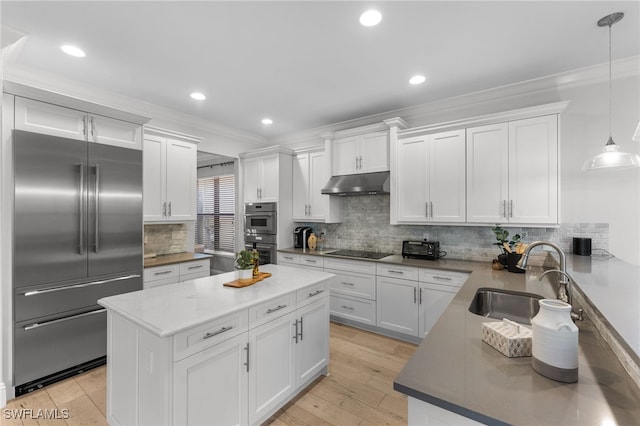 kitchen featuring white cabinets, appliances with stainless steel finishes, hanging light fixtures, and sink