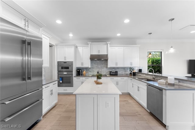 kitchen with a center island, sink, tasteful backsplash, decorative light fixtures, and stainless steel appliances