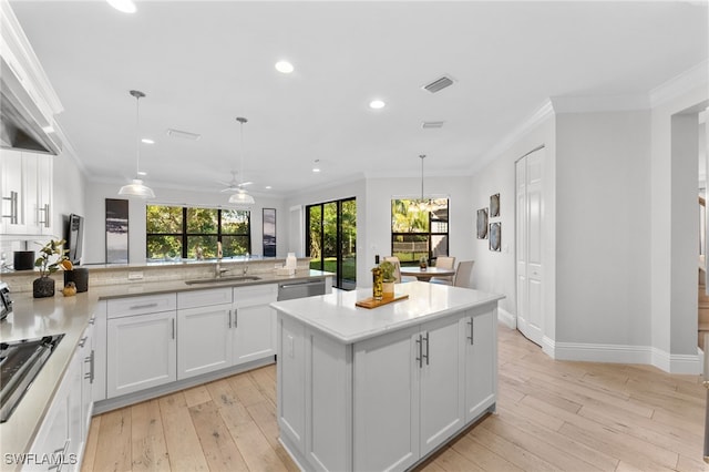 kitchen with ceiling fan, crown molding, pendant lighting, dishwasher, and white cabinets