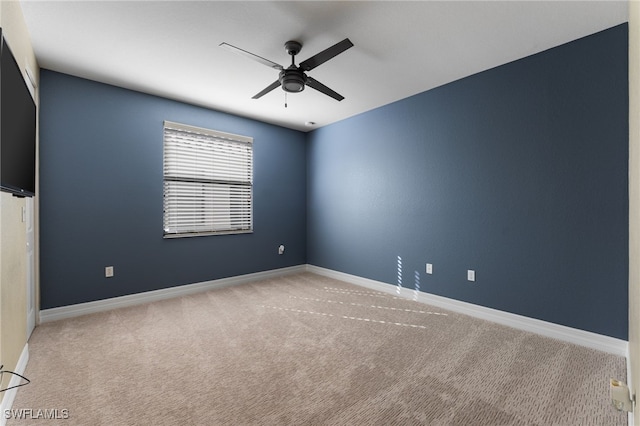 carpeted spare room featuring ceiling fan