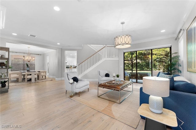 living room featuring a chandelier, light hardwood / wood-style floors, and ornamental molding