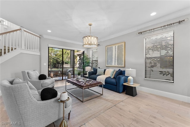 living room featuring light wood-type flooring, crown molding, and a chandelier