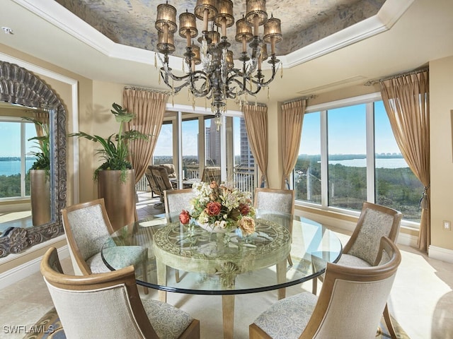 dining room featuring ornamental molding, a tray ceiling, and a chandelier