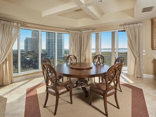 dining space featuring a water view, beam ceiling, and plenty of natural light