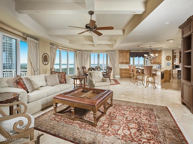 living room with ceiling fan with notable chandelier, coffered ceiling, and beam ceiling