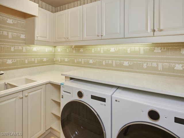 laundry room with sink, washer and clothes dryer, and cabinets