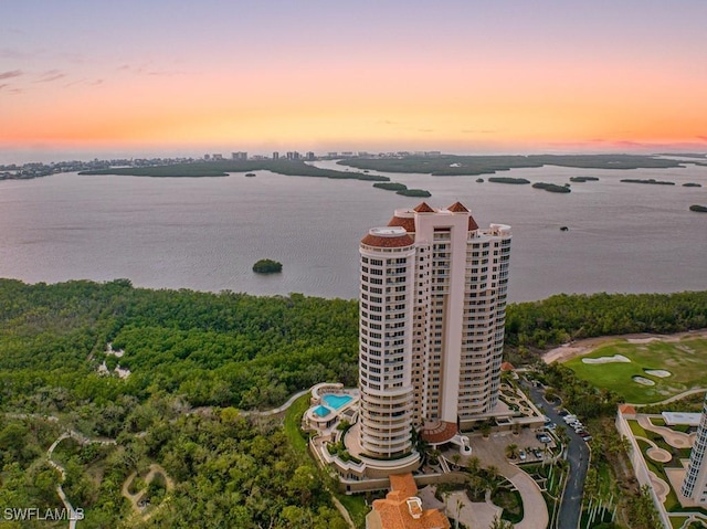 aerial view at dusk featuring a water view