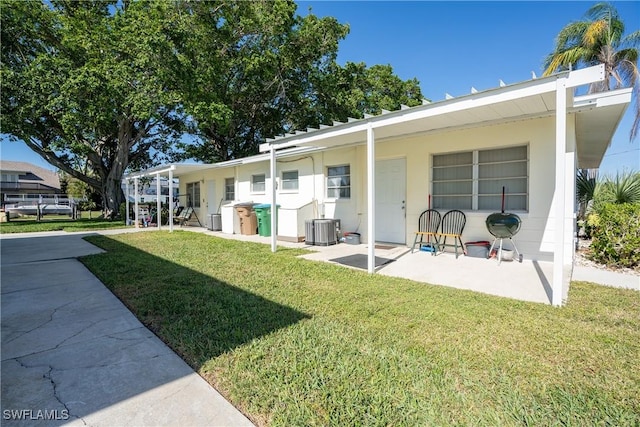 rear view of house with a lawn and central AC unit