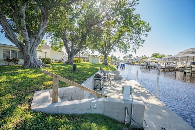 dock area featuring a water view and a yard