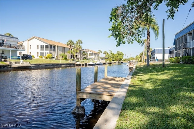 view of dock featuring a water view and a lawn