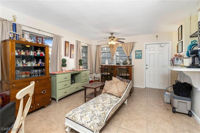 living area featuring light tile patterned floors and ceiling fan