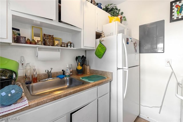 kitchen with electric panel, sink, white cabinets, and white appliances