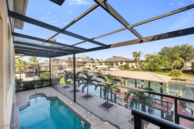 view of swimming pool featuring a lanai, a patio, and a water view