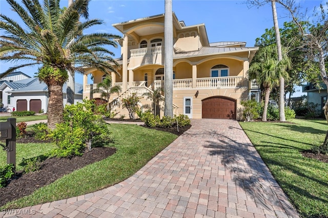 mediterranean / spanish house with a garage, a front lawn, and covered porch