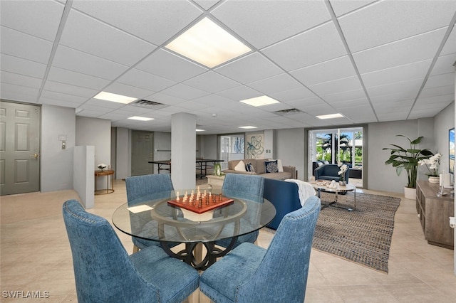 dining area featuring a paneled ceiling